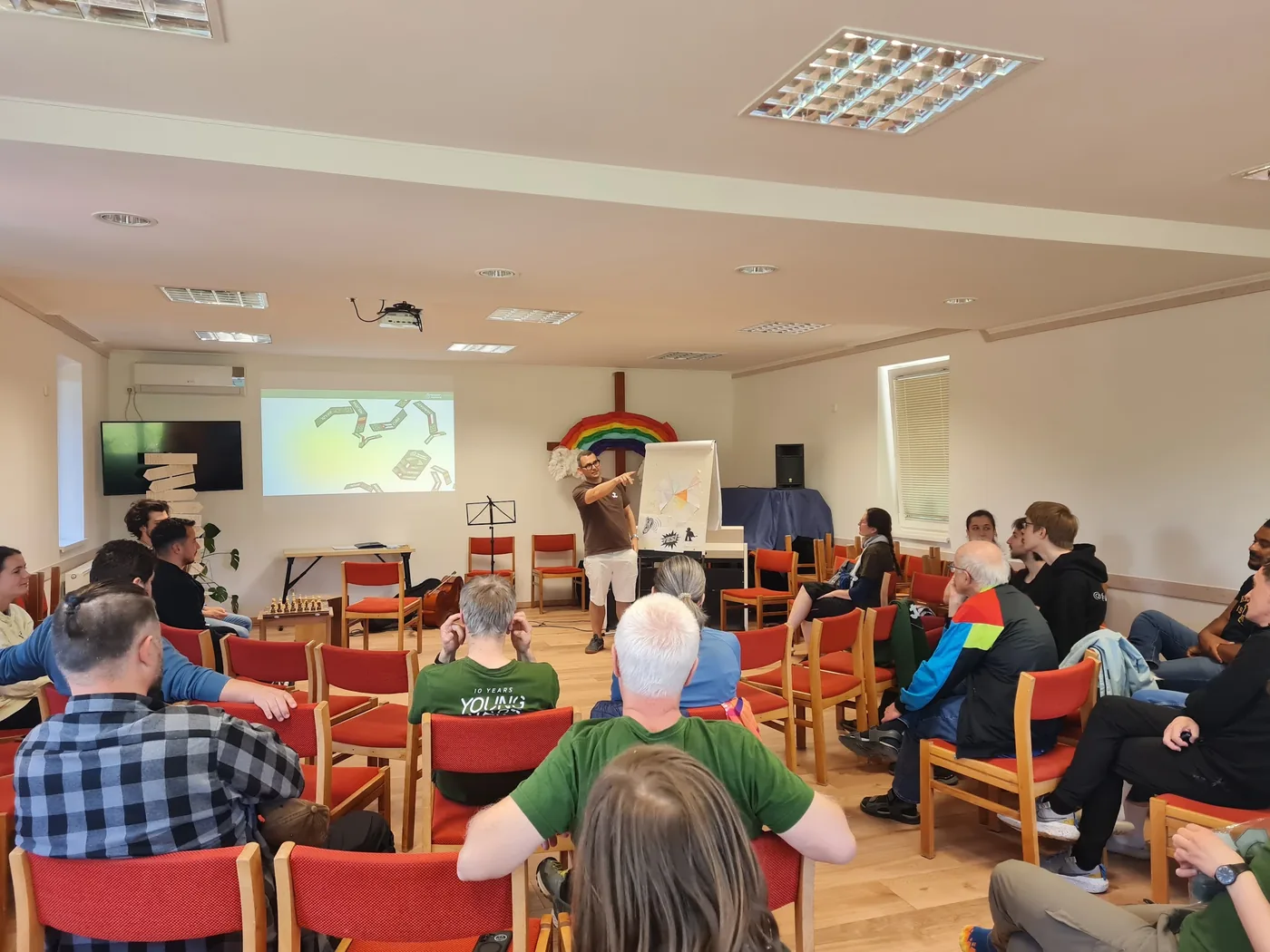 Übersicht des Seminarraums während einer Session, Referent am Flipchart, Beamer, Youngstars-Shirts im Publikum